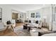 Bright living room featuring a modern sofa, neutral tones, hardwood floors, and an open layout to the dining area at 1749 Archdale Dr, Charlotte, NC 28210