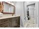 Bathroom featuring a shower, granite counters, decorative mirror, and under sink storage space at 188 Winding Forest Dr, Troutman, NC 28166