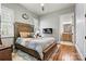 Cozy bedroom featuring a decorative fireplace, wood floors, and ensuite bathroom access at 188 Winding Forest Dr, Troutman, NC 28166