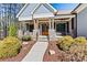 Charming home featuring a welcoming front porch with stone pillars and inviting wooden doors at 188 Winding Forest Dr, Troutman, NC 28166