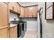 Well-organized laundry room with wood cabinets, shelving, and modern washer and dryer at 188 Winding Forest Dr, Troutman, NC 28166