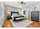 Stunning main bedroom with wood accent wall, dark furniture, and light colored rug at 188 Winding Forest Dr, Troutman, NC 28166