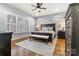 A spacious main bedroom boasts wood accent wall, dark furniture, and plenty of natural light at 188 Winding Forest Dr, Troutman, NC 28166