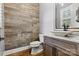 Stylish powder room boasts a wood accent wall, wood floors, vessel sink, and elegant fixtures at 188 Winding Forest Dr, Troutman, NC 28166