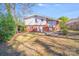 Exterior view of the home from the backyard, showcasing the expansive lawn, garden, and brick exterior at 2300 Highlawn Dr, Charlotte, NC 28212