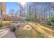 A peaceful backyard with a mix of lawn and wooded area, featuring a garden and patio area at 2300 Highlawn Dr, Charlotte, NC 28212