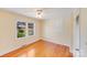 Bright bedroom featuring hardwood floors, a ceiling fan, and natural light from a window at 2300 Highlawn Dr, Charlotte, NC 28212