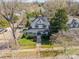 Aerial view of a two-story home with mature trees, a fenced yard, and a charming front porch at 234 N Race St, Statesville, NC 28677