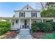 Inviting two-story home featuring a classic white facade, covered porch, and symmetrical window design at 234 N Race St, Statesville, NC 28677