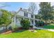 Classic two-story home featuring a covered front porch, mature trees, and a well-maintained lawn at 234 N Race St, Statesville, NC 28677