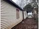 Side view of home with neglected siding and overgrown grass at 2501 Booker Ave, Charlotte, NC 28216