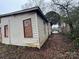 A neglected home with boarded up windows and overgrown yard at 2501 Booker Ave, Charlotte, NC 28216