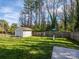 Large, fenced backyard with a storage shed, swing set, and lush green lawn at 2518 Eargle Rd, Charlotte, NC 28269