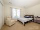 Cozy bedroom features lots of natural light, comfortable chair, and modern furniture at 2518 Eargle Rd, Charlotte, NC 28269