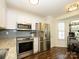 Kitchen features white cabinets, stainless steel appliances, and a view to a bright breakfast nook at 2518 Eargle Rd, Charlotte, NC 28269