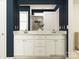 Bathroom featuring double sink vanity with white cabinets, dark blue walls and white framed mirror at 4187 Skyboat Cir, Fort Mill, SC 29715