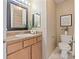 Warm-toned bathroom with wood vanity, decorative plant and a toilet with art in the background at 419 W 8Th St, Charlotte, NC 28202