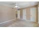 Neutral bedroom featuring a ceiling fan, plush carpeting, and two bright white doors at 419 W 8Th St, Charlotte, NC 28202