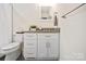 This bathroom features white cabinets, a gray countertop, and black and white mosaic tile floor at 4329 Castleton Rd, Charlotte, NC 28211