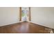 A room featuring neutral walls, hardwood floors, a corner window with tree view, and natural light at 4329 Castleton Rd, Charlotte, NC 28211