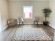 Bright bedroom featuring neutral walls, hardwood floors, two chairs, and a potted tree at 507 E Maple Ave, Gastonia, NC 28054