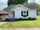 Charming white home with black shutters, a cozy porch, and a well-manicured lawn at 507 E Maple Ave, Gastonia, NC 28054