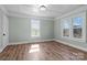 Bright bedroom with wood-look floors, paneled ceiling, and natural light from large windows at 512 Washington St, Cramerton, NC 28032