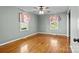 Sun-filled bedroom with hardwood floors and two windows with pink curtains at 512 Washington St, Cramerton, NC 28032