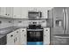 Kitchen featuring stainless steel appliances, dark granite countertops, white cabinets, and mosaic tile backsplash at 512 Washington St, Cramerton, NC 28032