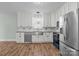 White kitchen with stainless steel appliances, a farmhouse sink, and ample cabinet space and wood-look flooring at 512 Washington St, Cramerton, NC 28032