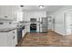 Bright kitchen with white cabinetry, stainless steel appliances, granite countertops, and wood-look flooring at 512 Washington St, Cramerton, NC 28032