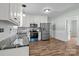 Bright kitchen with white cabinetry, stainless steel appliances, granite countertops, and wood-look flooring at 512 Washington St, Cramerton, NC 28032