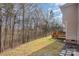 Large backyard with a wood deck and a view of the wooded area at 6087 Diamond Pl, Harrisburg, NC 28075