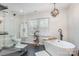 Modern bathroom featuring a sleek soaking tub, black marble floors, and glass enclosed shower at 6087 Diamond Pl, Harrisburg, NC 28075