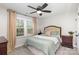 Comfortable bedroom with a ceiling fan, soft bedding, and neutral colors at 6087 Diamond Pl, Harrisburg, NC 28075