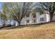 Two story brick home with a manicured lawn and blooming tree providing shade at 6087 Diamond Pl, Harrisburg, NC 28075