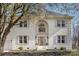 Stately two-story white brick home featuring an elegant arched window above the front entrance at 6087 Diamond Pl, Harrisburg, NC 28075