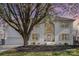 Elegant white brick home featuring a two-car garage, a manicured yard, and a beautiful tree at 6087 Diamond Pl, Harrisburg, NC 28075