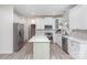 Modern kitchen features a center island with white cabinets and stainless steel appliances at 6087 Diamond Pl, Harrisburg, NC 28075