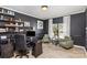 Home office with a dark wood desk, comfortable seating, and natural light from the window at 6087 Diamond Pl, Harrisburg, NC 28075