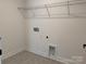 Laundry room with gray tile floor, utility sink, and wire rack for storage at 619 Amberjack Pl, York, SC 29745