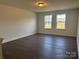 Living room with wood floor and two windows looking out onto a landscaped yard at 619 Amberjack Pl, York, SC 29745