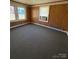 Bedroom with gray carpet, wood paneled walls, and a window with an air conditioner at 701 Betty St, Gastonia, NC 28054