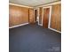 Bedroom with gray carpet, wood paneled walls, and 2 doors at 701 Betty St, Gastonia, NC 28054