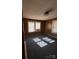 Bedroom featuring carpet flooring, wood paneling, and natural light from two windows at 701 Betty St, Gastonia, NC 28054