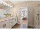 Bright bathroom featuring double vanity, modern fixtures, granite countertops, open to bedroom and shower at 8029 Joy Crossing Ln, Charlotte, NC 28214