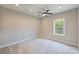 Bright bedroom with plush carpet, ceiling fan, and large window showing nature views at 8029 Joy Crossing Ln, Charlotte, NC 28214