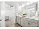 Bright bathroom with double sinks, gray cabinets, and wood-look flooring opens to the bedroom at 815 Foxmeade Ct, Salisbury, NC 28144