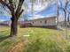 Home's backyard with a deck, grassy yard, mature trees, and a chain link fence at 82 22Nd Nw Ave, Hickory, NC 28601