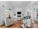 Bright living room boasts hardwood floors, fireplace, tv, and ample seating perfect for entertaining at 102 Stone Point Ct, Mooresville, NC 28117